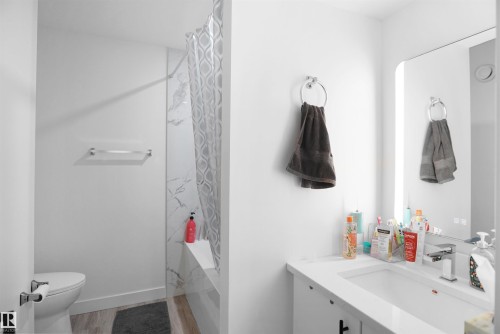 The bathroom features a modern vanity with a rectangular sink and a sleek faucet - Edmonton, AB - Indoor Photo Showing Bathroom