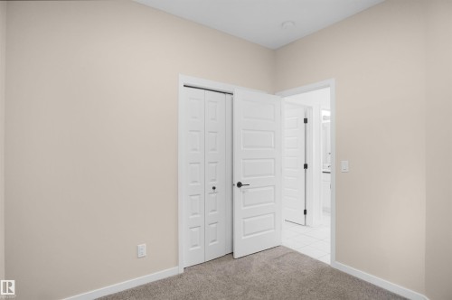 This room features neutral-toned walls, carpeted flooring, and white trim - Edmonton, AB - Indoor Photo Showing Other Room