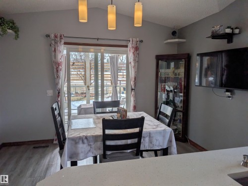 The dining area features a vaulted ceiling with pendant lighting and sliding glass doors that open to the exterior - 65 Coloniale Way, Beaumont, AB - Indoor Photo Showing Dining Room