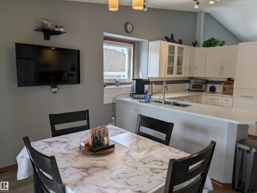 Kitchen featuring white cabinetry, a kitchen island with a sink, and light countertops - 65 Coloniale Way, Beaumont, AB - Indoor