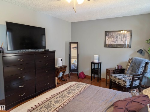 This room features light grey walls, hardwood flooring, and a ceiling fan - 65 Coloniale Way, Beaumont, AB - Indoor Photo Showing Bedroom