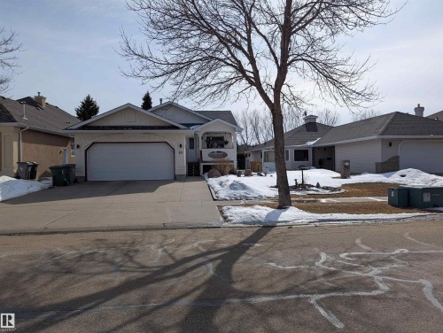 The property features a concrete driveway leading to an attached garage - 65 Coloniale Way, Beaumont, AB - Outdoor With Facade