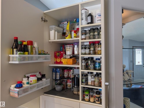 The property features a well-organized pantry with built-in shelving, providing ample storage - 65 Coloniale Way, Beaumont, AB - Indoor