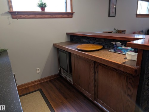 Entertainment area featuring wood paneling, a built-in appliance, and a stone-style accent wall - 65 Coloniale Way, Beaumont, AB - Indoor