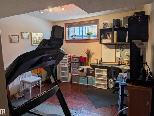 This versatile room features a window with wood trim, recessed lighting, and durable flooring, providing a functional space - 65 Coloniale Way, Beaumont, AB - Indoor