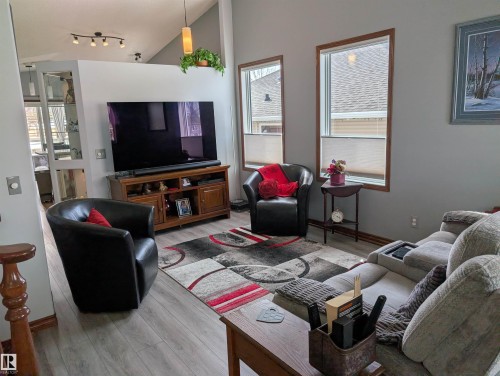 Living area featuring light-colored flooring, neutral wall paint, and windows with blinds - 65 Coloniale Way, Beaumont, AB - Indoor Photo Showing Living Room