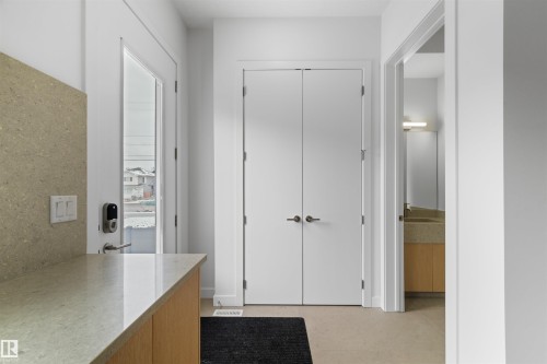 Entryway featuring a light-toned countertop, white cabinetry, and a glass-paneled door - 14037 104 Avenue, Edmonton, AB - Indoor Photo Showing Other Room