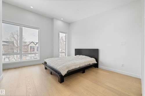 Room with light wood flooring, white walls, and large windows - 14037 104 Avenue, Edmonton, AB - Indoor Photo Showing Bedroom