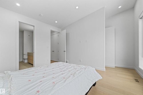 This room features light-colored hardwood flooring, recessed lighting, and a window providing natural light - 14037 104 Avenue, Edmonton, AB - Indoor Photo Showing Bedroom