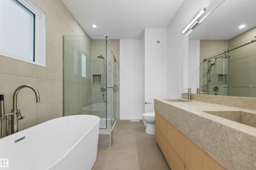 Bathroom featuring a freestanding soaking tub with a floor-mounted faucet, a walk-in shower with a glass enclosure, and a vanity with dual sinks - 14037 104 Avenue, Edmonton, AB - Indoor Photo Showing Bathroom