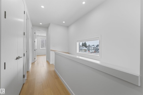 The property features a bright hallway with light-toned hardwood flooring, recessed lighting, and white walls - 14037 104 Avenue, Edmonton, AB - Indoor Photo Showing Other Room