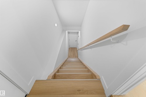 Staircase featuring light wood treads, white risers, and a minimalist wood handrail - 14037 104 Avenue, Edmonton, AB - Indoor Photo Showing Other Room
