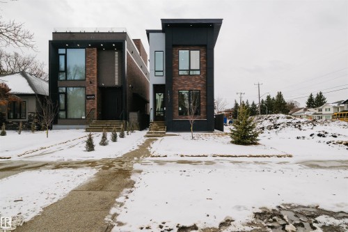 The property features a modern exterior with dark siding and brick accents, large windows, and a flat roofline - 14037 104 Avenue, Edmonton, AB - Outdoor With Facade