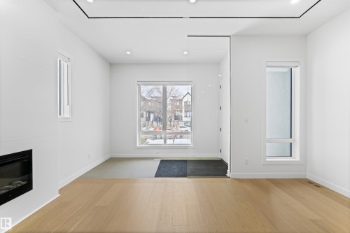 Living area featuring light-toned flooring, a fireplace, and recessed lighting - 14037 104 Avenue, Edmonton, AB - Indoor With Fireplace