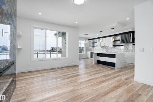 Spacious open-concept living area featuring light-toned flooring, a large window, and recessed lighting - 219 Crystal Creek Dr, Leduc, AB - Indoor Photo Showing Kitchen With Upgraded Kitchen