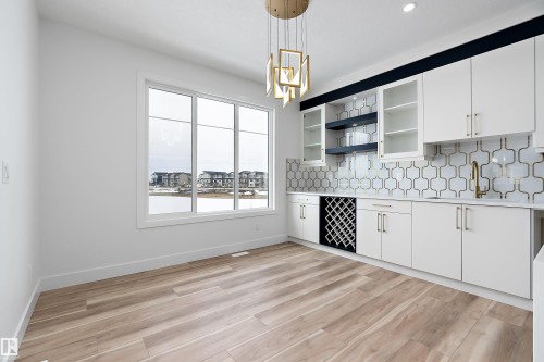 This room features light wood-look flooring and a large window providing expansive views - 219 Crystal Creek Dr, Leduc, AB - Indoor