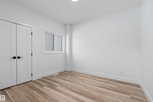 Well-lit room featuring light-toned flooring, white walls, and a window with blinds - 219 Crystal Creek Dr, Leduc, AB - Indoor Photo Showing Other Room