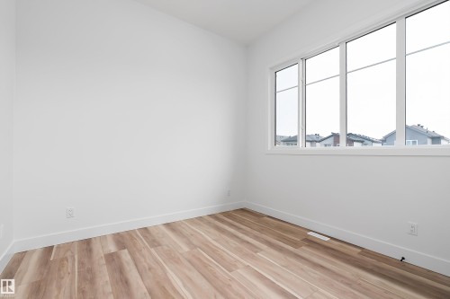 Room featuring light wood-style flooring and a large window providing natural light - 219 Crystal Creek Dr, Leduc, AB - Indoor Photo Showing Other Room