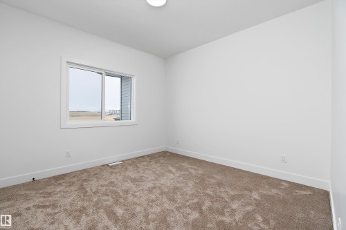 This room features white walls, a single window with white trim, and a neutral-toned carpet - 219 Crystal Creek Dr, Leduc, AB - Indoor Photo Showing Other Room