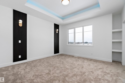 This room features a neutral carpet, white walls, and a recessed ceiling with accent lighting - 219 Crystal Creek Dr, Leduc, AB - Indoor Photo Showing Other Room