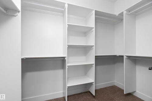 The property features a spacious closet with white shelving and hanging rods - 219 Crystal Creek Dr, Leduc, AB - Indoor With Storage