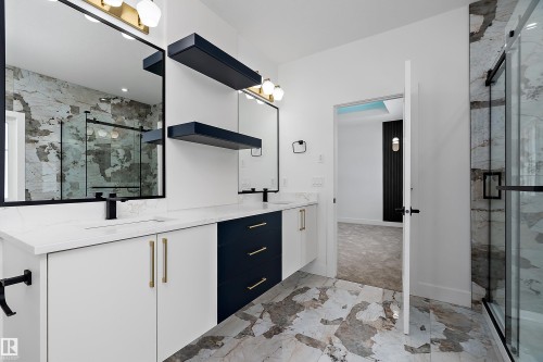 This bathroom features a double vanity with white and navy cabinetry, gold hardware, and a white countertop - 219 Crystal Creek Dr, Leduc, AB - Indoor Photo Showing Other Room