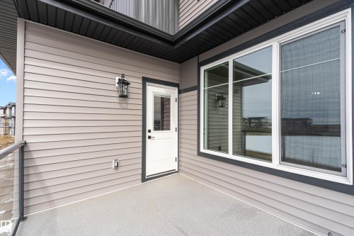 The property features a balcony with a gray textured surface and a partial glass railing - 219 Crystal Creek Dr, Leduc, AB - Outdoor With Deck Patio Veranda With Exterior