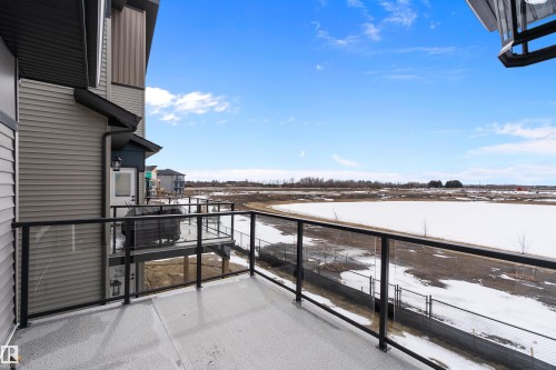 The property features an outdoor balcony with a glass railing, providing expansive views of the surrounding landscape - 219 Crystal Creek Dr, Leduc, AB - Outdoor With View With Exterior