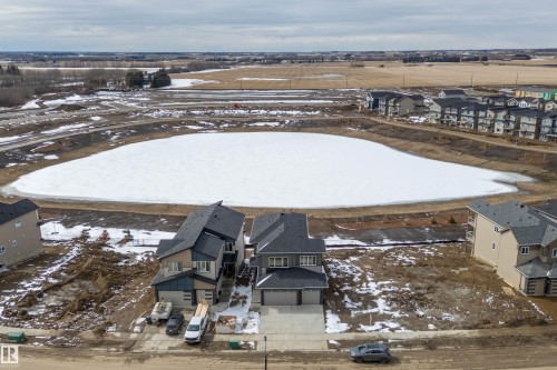 This property features a contemporary architectural style with a dark grey roof and light-colored siding - 219 Crystal Creek Dr, Leduc, AB - Outdoor With View