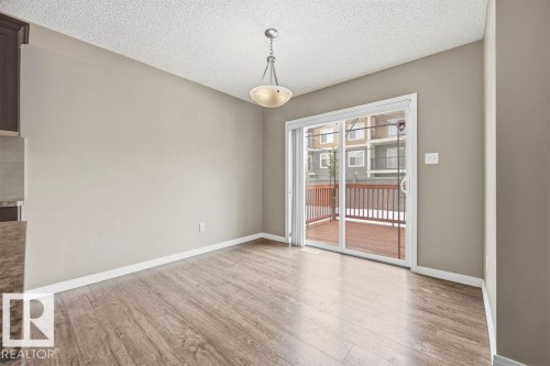 This room features light-colored walls, light wood-style flooring, and a glass sliding door that provides access to a wooden deck - 7873 170A Avenue, Edmonton, AB - Indoor Photo Showing Other Room