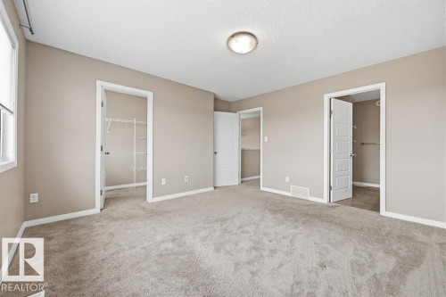 The room features carpeted flooring, neutral-toned walls, and a ceiling light fixture - 7873 170A Avenue, Edmonton, AB - Indoor Photo Showing Other Room