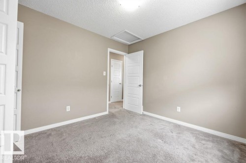 This room features neutral-toned walls, a textured ceiling, and gray carpet - 7873 170A Avenue, Edmonton, AB - Indoor Photo Showing Other Room