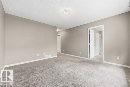The property features a spacious room with light gray walls, gray carpeting, and white trim - 7873 170A Avenue, Edmonton, AB - Indoor Photo Showing Other Room