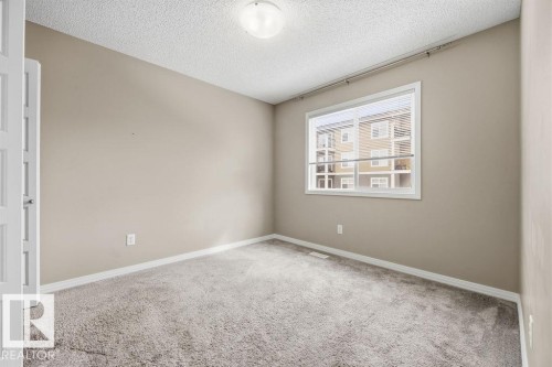 The property features neutral-toned walls, a window with blinds, and carpeting - 7873 170A Avenue, Edmonton, AB - Indoor Photo Showing Other Room