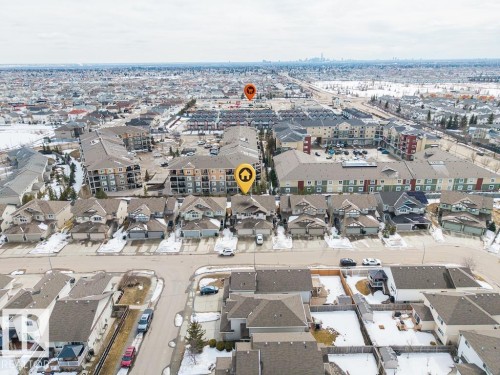 Aerial view showcasing the property's location within a residential neighborhood with visible community developments and distant city skyline - 7873 170A Avenue, Edmonton, AB - Outdoor With View
