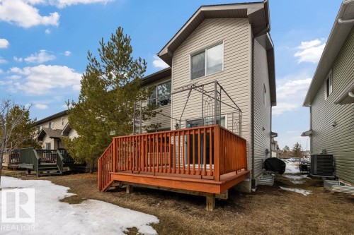 The property features a wooden deck with railing, a metal pergola structure, and siding exterior - 7873 170A Avenue, Edmonton, AB - Outdoor