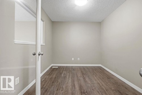 Room featuring wood-style flooring, light-colored walls, and a window - 7873 170A Avenue, Edmonton, AB - Indoor Photo Showing Other Room