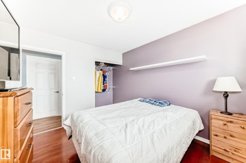 This room features hardwood flooring, a closet with shelving, and a wall-mounted shelf - 7512 136 Avenue, Edmonton, AB - Indoor Photo Showing Bedroom