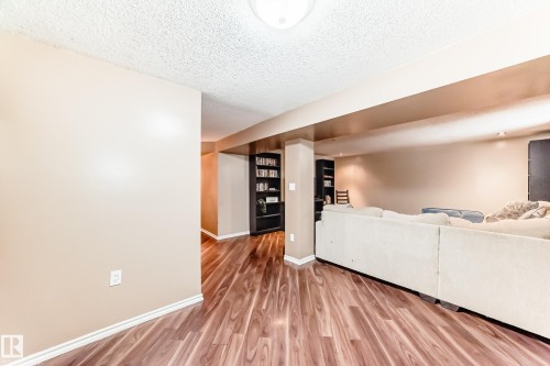 This spacious interior features wood-look flooring and light-toned walls - 7512 136 Avenue, Edmonton, AB - Indoor Photo Showing Other Room