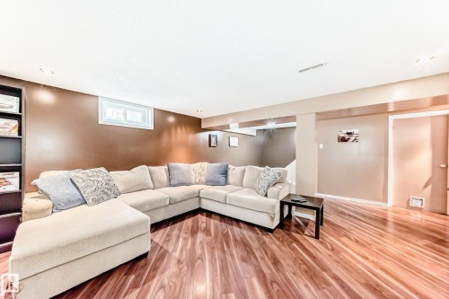 Living room with warm-toned walls, recessed lighting, and rich wood-style flooring - 7512 136 Avenue, Edmonton, AB - Indoor Photo Showing Living Room