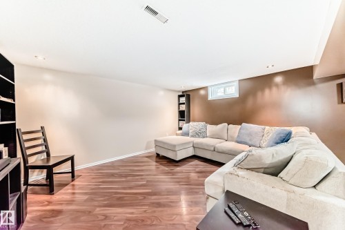 This living space features warm-toned walls, recessed lighting, and rich wood flooring - 7512 136 Avenue, Edmonton, AB - Indoor