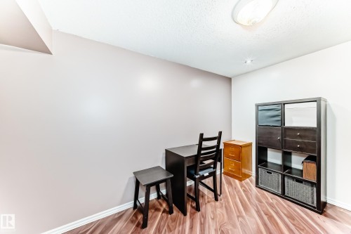 This room features wood-look flooring and light-colored walls - 7512 136 Avenue, Edmonton, AB - Indoor Photo Showing Other Room