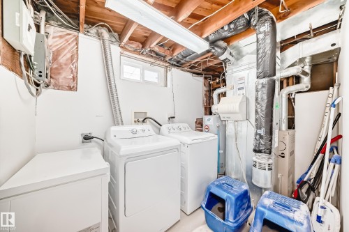 Dedicated laundry area featuring a washer and dryer, exposed ceiling joists, and a window for natural light - 7512 136 Avenue, Edmonton, AB - Indoor Photo Showing Laundry Room