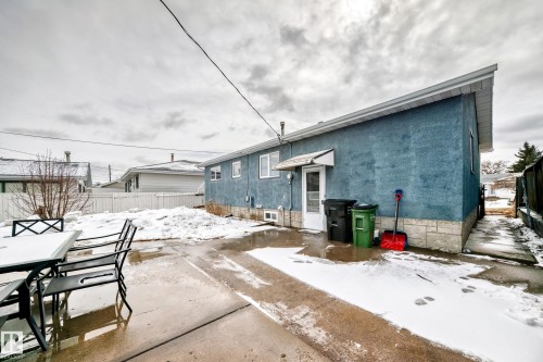 The property features a blue stucco exterior with white trim and multiple windows - 7512 136 Avenue, Edmonton, AB - Outdoor