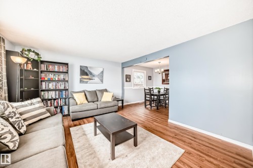 The main living area features hardwood flooring and light blue walls, providing an inviting atmosphere - 7512 136 Avenue, Edmonton, AB - Indoor Photo Showing Living Room