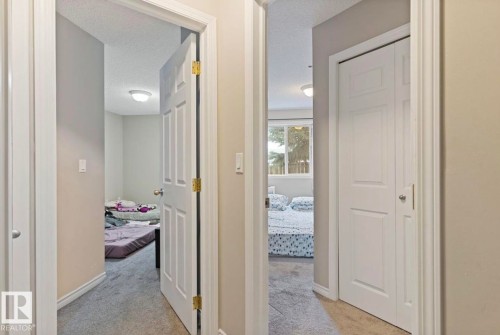 The property features neutral-toned walls, carpeted flooring, and white trim throughout - 103 12110 119 Ave, Edmonton, AB - Indoor Photo Showing Other Room