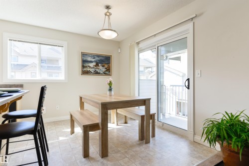 Dining area featuring a window, a sliding glass door with balcony access, and tile flooring - 67 12050 17 Avenue, Edmonton, AB - Indoor Photo Showing Dining Room