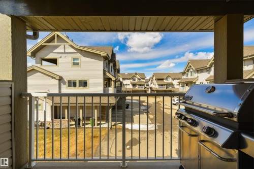 The property offers a balcony with a view of the surrounding residential buildings and a clear blue sky - 67 12050 17 Avenue, Edmonton, AB - Outdoor With Balcony