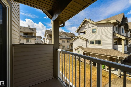 The property includes a private balcony with a metal railing, offering views of the surrounding residential structures - 67 12050 17 Avenue, Edmonton, AB - Outdoor With Balcony With Exterior