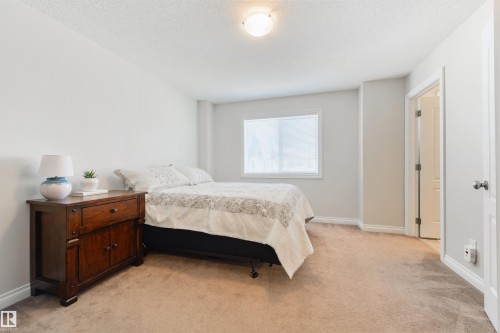 Bedroom featuring light-colored walls, carpeted flooring, and a window with blinds - 67 12050 17 Avenue, Edmonton, AB - Indoor Photo Showing Bedroom